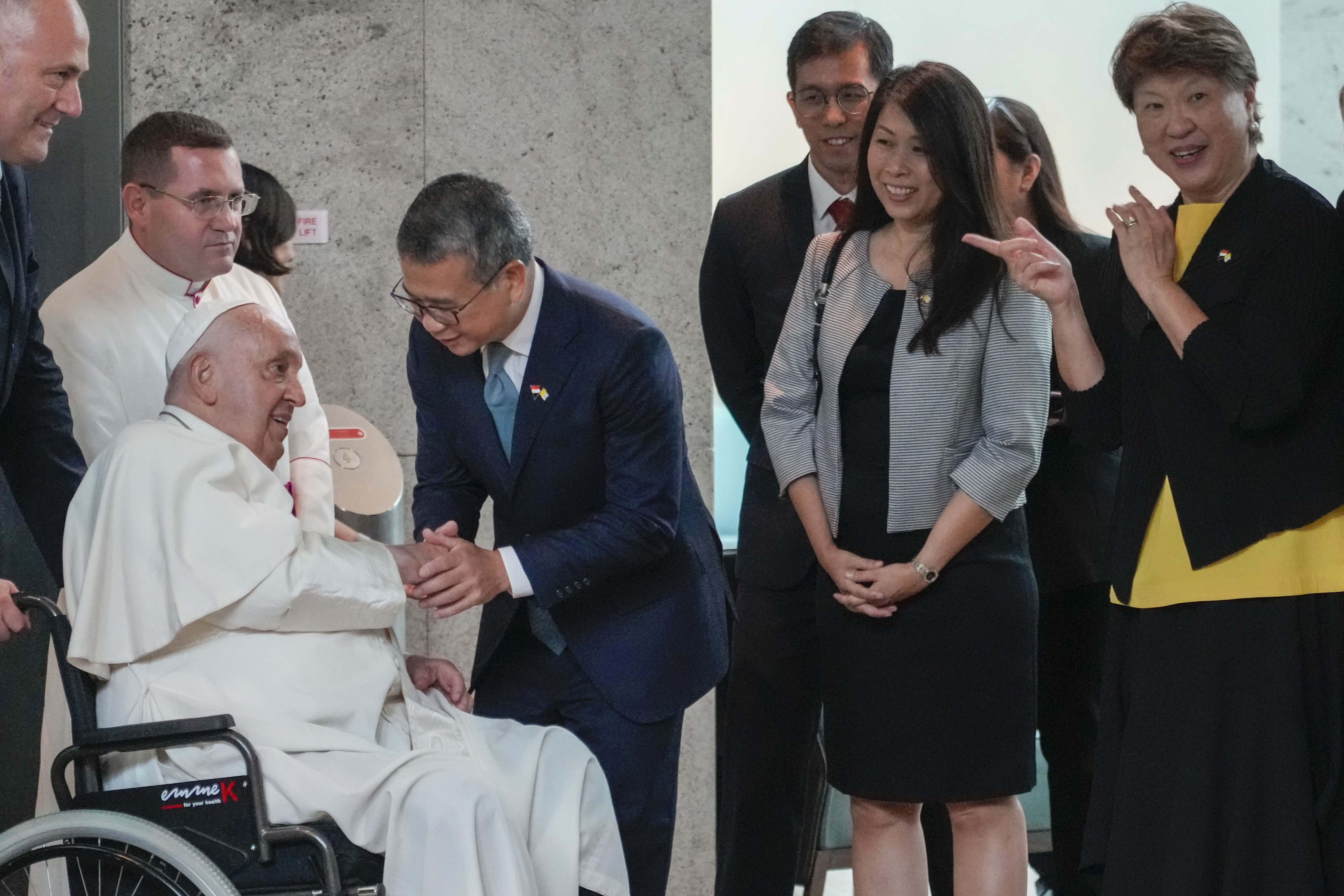 From left, Pope Francis is welcomed by Singapore's Minister of Culture, Community and Youth Edwin Tong and his wife (name not given) and Ambassador of Singapore to the Holy See Ang Janet Guat Har as he arrives at Singapore Changi International Airport, Wednesday, Sept. 11. Pope Francis is heading to Singapore for the final leg of his 11-day trip to Asia and Oceania. (AP photo/Gregorio Borgia)