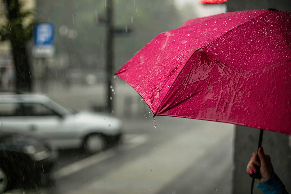 A red umbrella in the rain (Unsplash/Erik Witsoe)