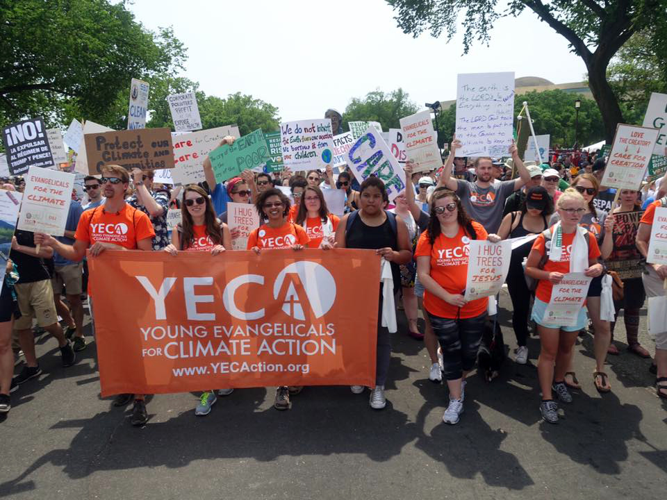 Young people march with banner and signs.