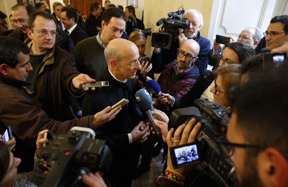 Msgr. Fernando Ocariz, Vicar General of Opus Dei, Rome, Jan. 24, 2017. Overhead view of prelate surrounded by journalists extending microphones and cell phones.
