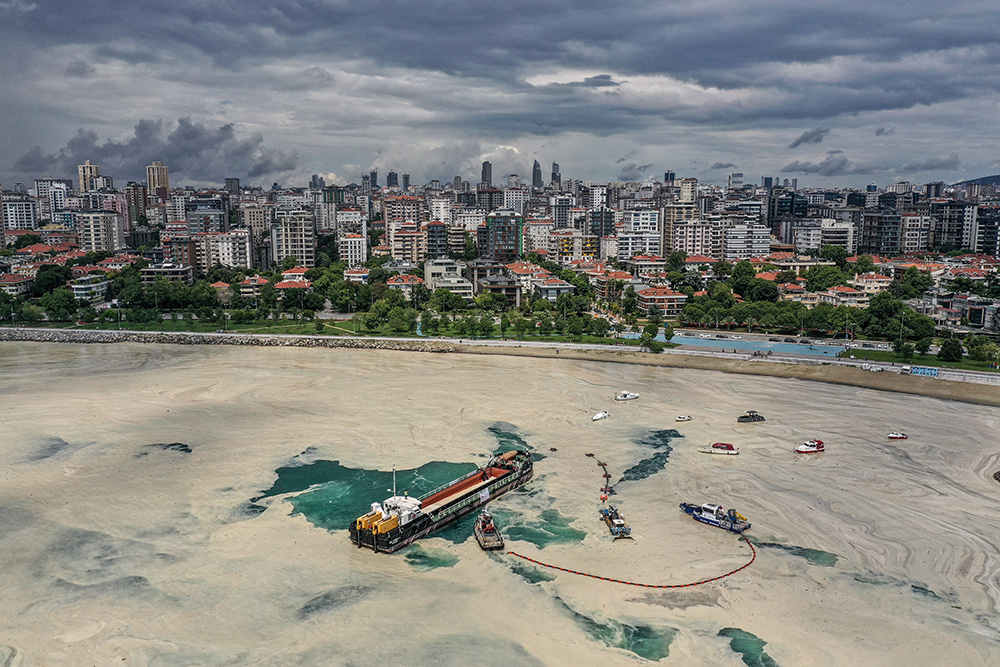 Sea-surface-cleaning vessels and barrier-laying boats of Istanbul clean up sea snot June 15, 2021. The thick slimy layer of the organic matter, also known as marine mucilage, is spreading through the Sea of Marmara and posing a threat to marine life and the fishing industry. (CNS/Reuters/Umit Bektas)