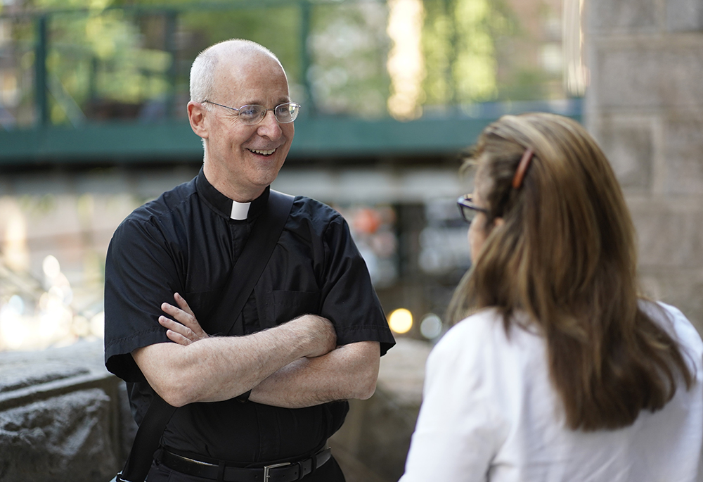 Jesuit Fr. James Martin, author and editor at large at America Media, chats with a woman after celebrating a Mass at St. Paul the Apostle Church in New York City June 25, 2022, for participants of the Outreach LGBTQ Catholic Ministry Conference. (CNS/Gregory A. Shemitz)