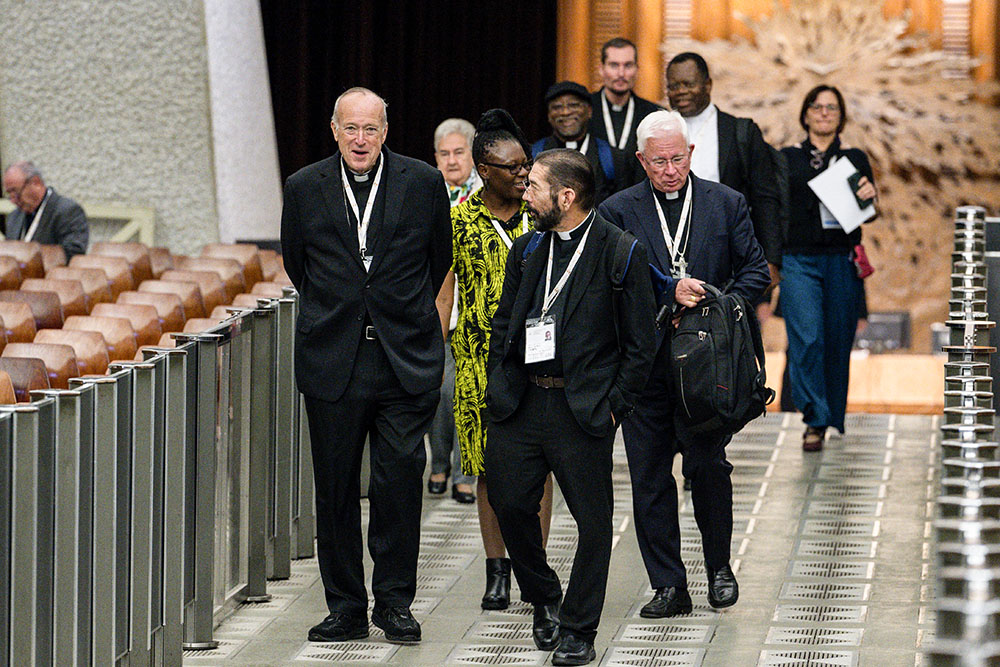 Cardinal Robert McElroy of San Diego, left, and Bishop Daniel Flores of Brownsville, Texas, arrive for a working session of the synod on synodality in the Paul VI Audience Hall at the Vatican Oct. 11, 2024. (CNS/Vatican Media)