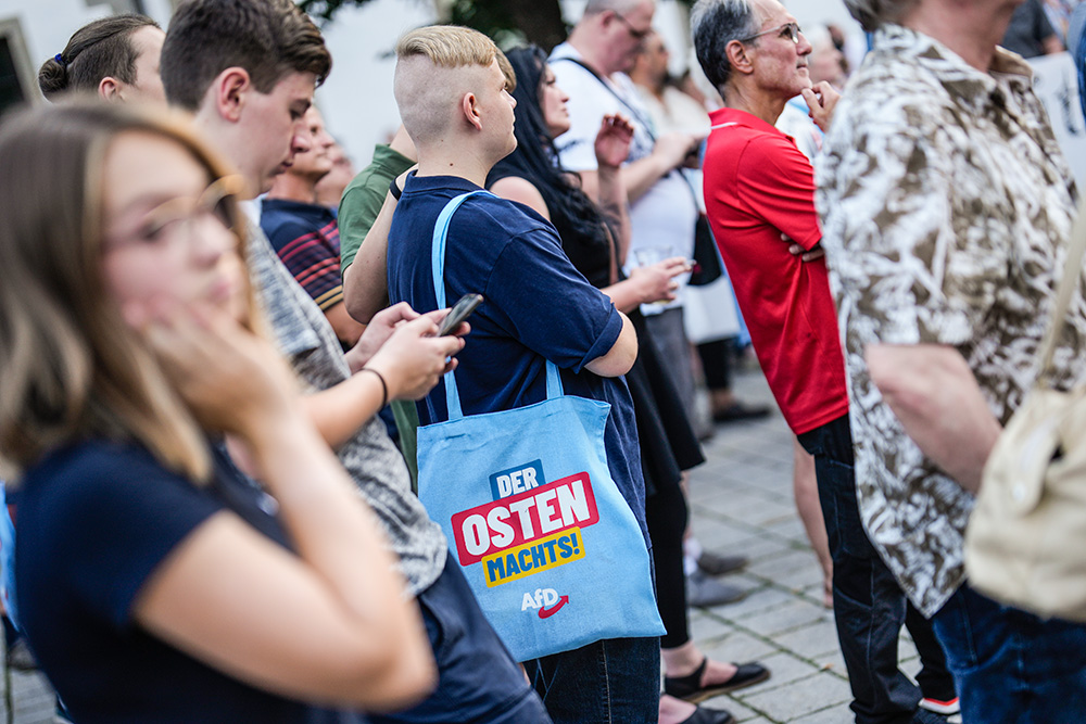 A young man with an AfD bag reading, "The East does it," attends a campaign rally of the far-right Alternative for Germany party in Suhl in the German state of Thuringia Aug. 13. (AP/Markus Schreiber)