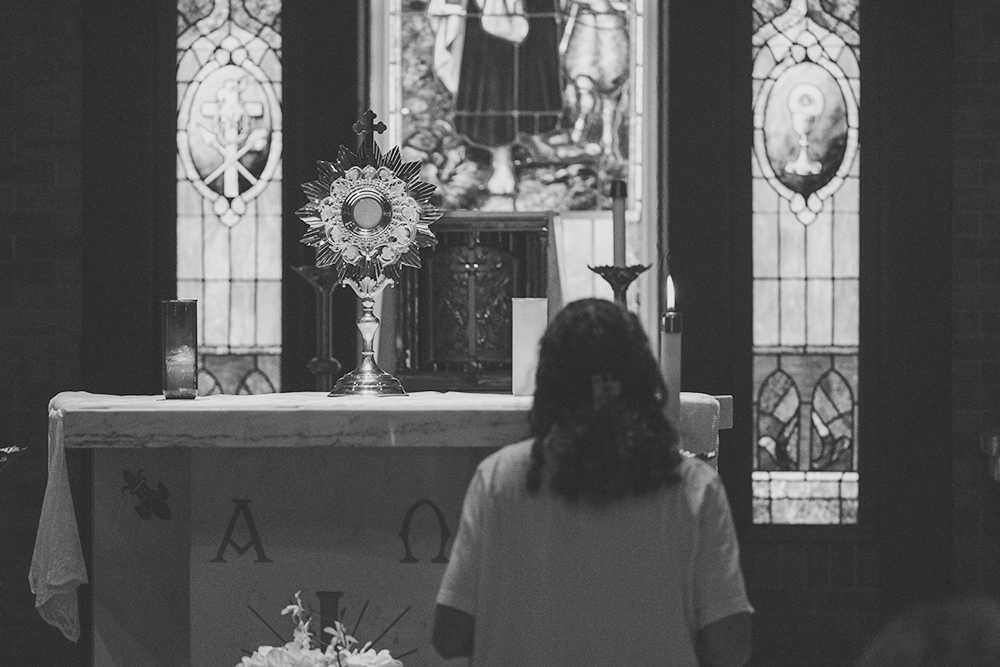 Someone standing before an altar in a church (Unsplash/Matea Gregg)