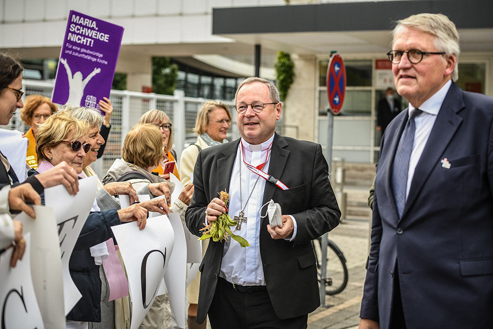 The co-presidents of Germany's Synodal Path project, Bishop Georg Bätzing, president of the German bishops' conference, and Thomas Sternberg, president of the Central Committee of German Catholics, speak to women during a protest by Maria 2.0 and We Are Church outside the Synodal Assembly in Frankfurt, Germany, Sept. 30, 2021. (CNS/KNA/Julia Steinbrecht)