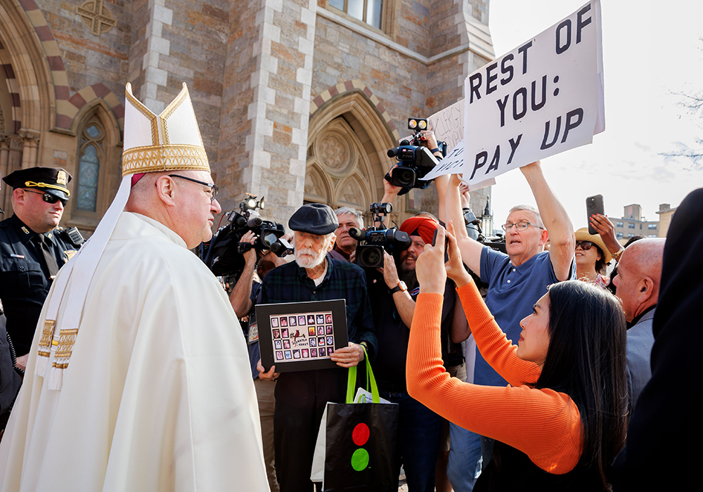 Archbishop Richard Henning speaks with demonstrators outside Boston's Cathedral of the Holy Cross before his installation Mass as archbishop of Boston, on Oct. 31. (OSV News/The Pilot/Gregory L. Tracy)