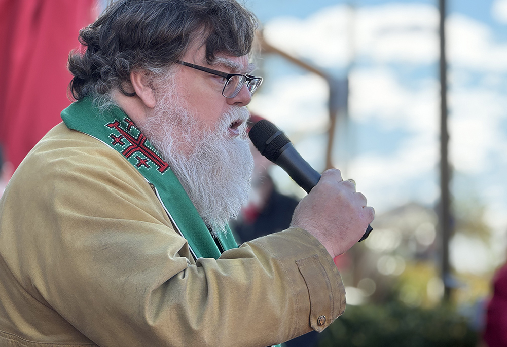 Fr. Ty Hullinger, pastor of Transfiguration Catholic Community in Baltimore, stopped to pray and support for nurses rallying outside the fall meeting of the U.S. Conference of Catholic Bishops, Nov. 12 in Baltimore. (NCR photo/Rhina Guidos)