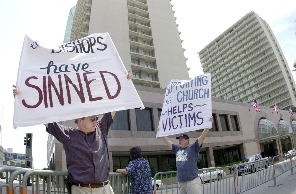 Protestors hold signs.