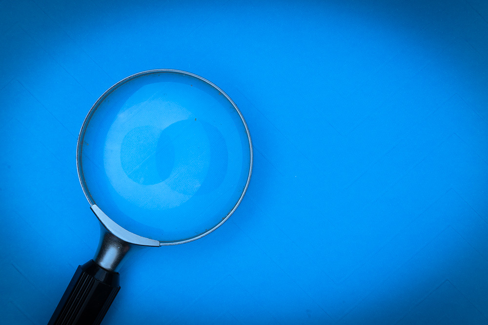 Magnifying glass on a blue background (Pixabay/Markus Winkler)