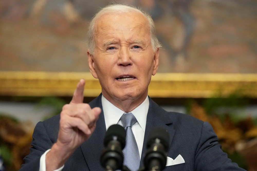 Biden standing at podium gestures while speaking.