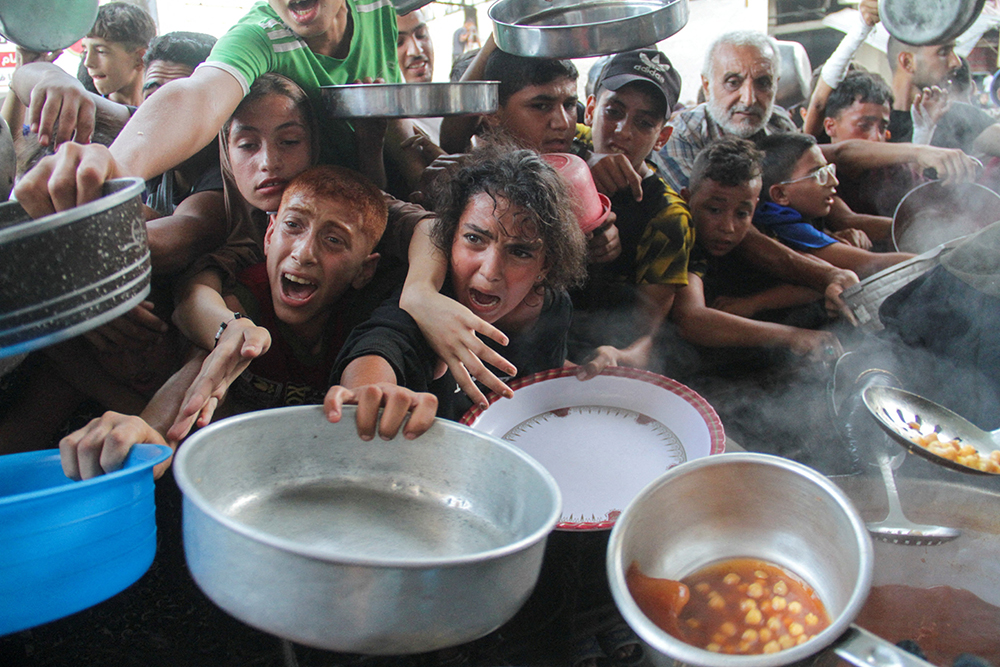 Young Palestinians gather to receive food cooked by a charity kitchen in the northern Gaza Strip Sept. 11, 2024, amid the Israel-Hamas conflict. (OSV News/Reuters/Mahmoud Issa)