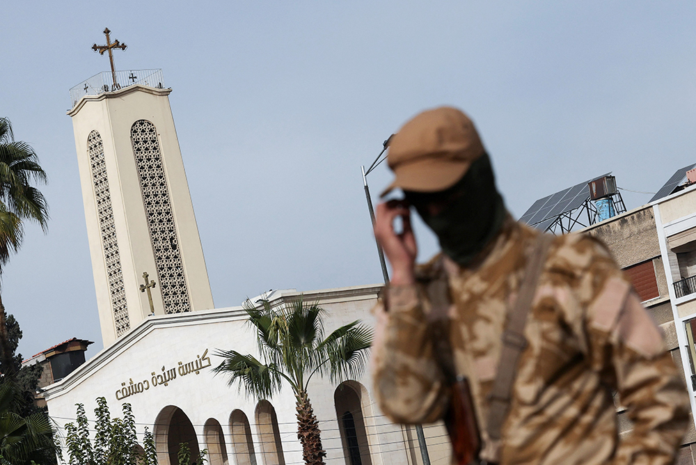 Un combatiente rebelde custodia la calle frente a la Iglesia de Nuestra Señora de Damasco en Siria, el 11 de diciembre de 2024, después de que los rebeldes tomaran la capital y derrocaran a Bashar al-Assad. (Foto: OSV News/Reuters/Amr Abdallah Dalsh)