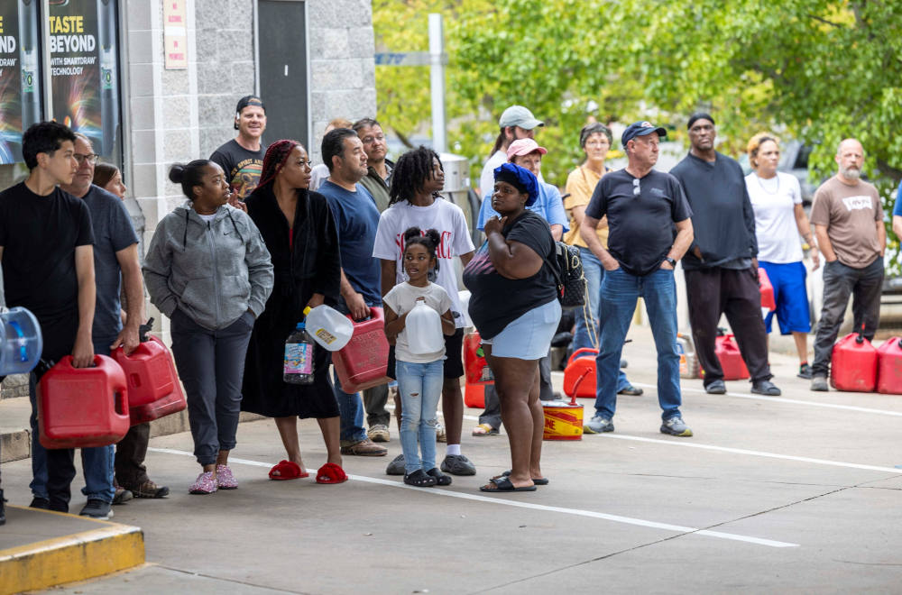 Asheville, N.C., residents residents line up for gasoline at a gas station in Asheville Sept. 29, 2024. The remnants of Tropical Storm Helene caused widespread flooding, downed trees and power outages in western North Carolina. The storm made landfall the night of Sept. 27 in Florida's Big Bend region as a Category 4 hurricane and was downgraded to a tropical storm the next morning. (OSV News photo/Travis Long, The News & Observer handout via Reuters)