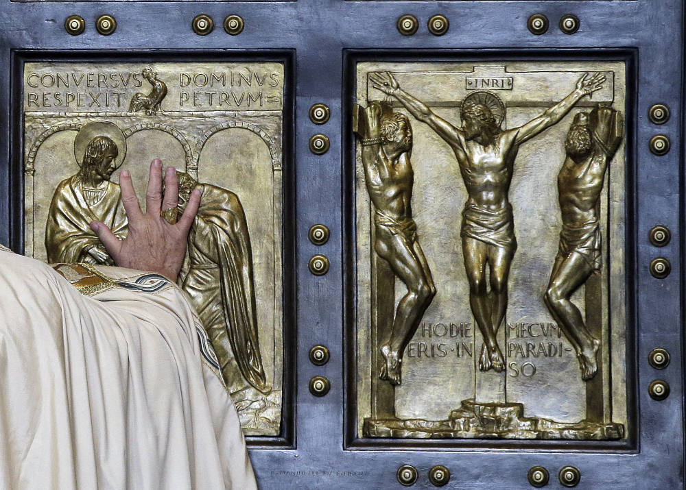 Pope Francis pushes open the Holy Door of St. Peter's Basilica, formally launching the Holy Year of Mercy, at the Vatican, Tuesday, Dec. 8, 2015. (AP Photo/Gregorio Borgia, File)