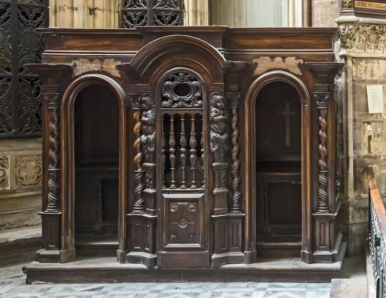 Ornate, carved wooden confessional box.