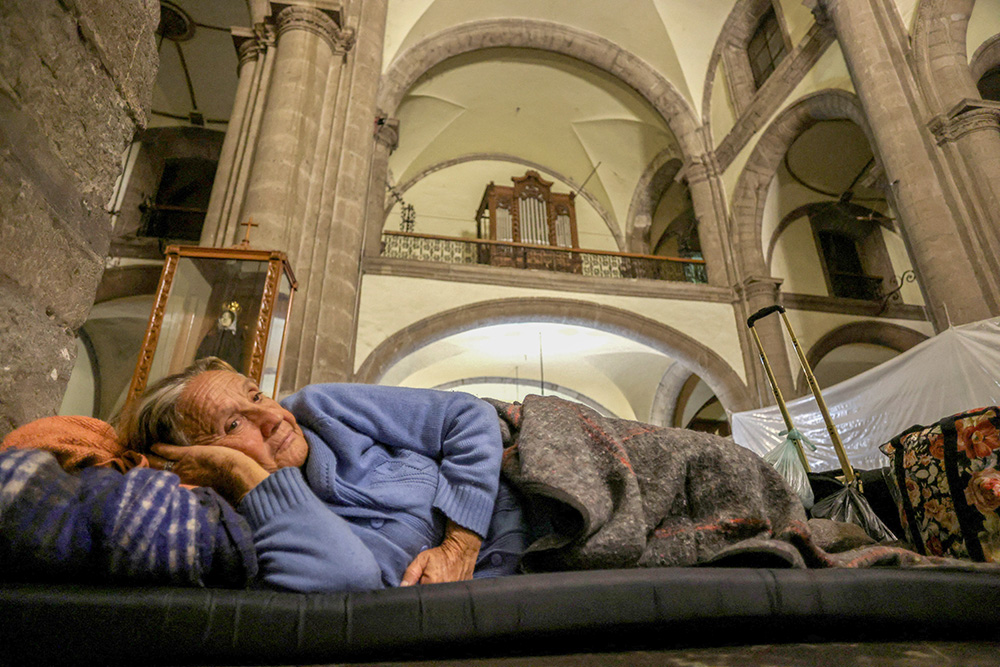 An elderly migrant woman from Venezuela rests as she shelters for the night at Our Lady of the Solitude Church in Mexico City Nov. 27, 2023, as she and other migrants wait for an appointment to be set up with U.S. Customs and Border Protection. (OSV News/Reuters/Gustavo Graf)