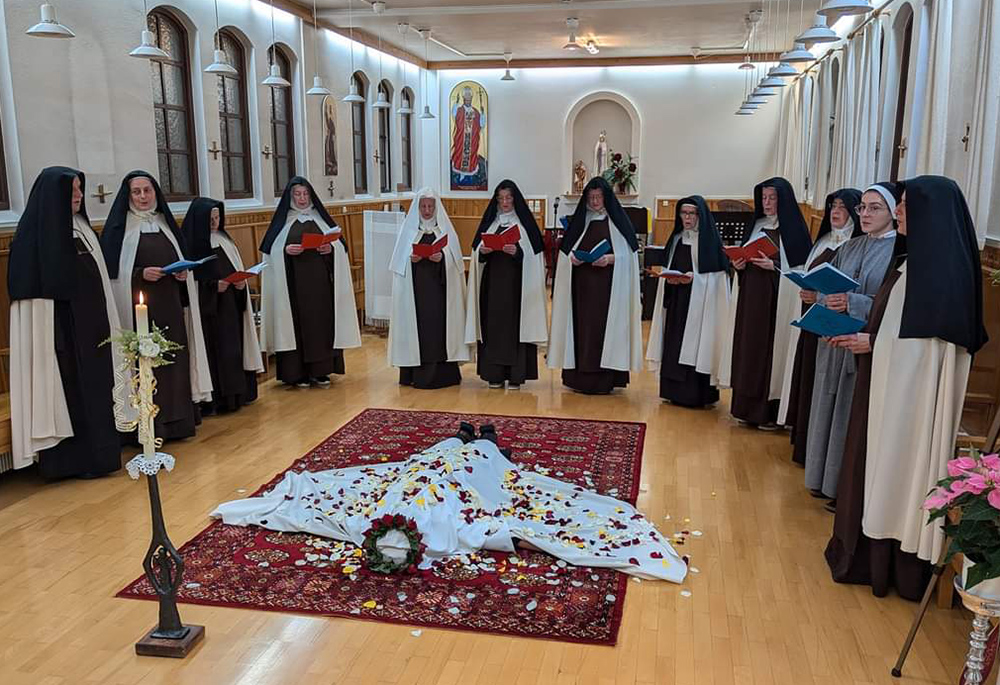 The Discalced Carmelite nuns of Hafnarfjordur, Iceland, celebrate the first vows of Sister Karolina. The newly professed sister lies on the ground with her hands forming a cross and the community invokes the Holy Spirit by singing the hymn "Te Deum." (Courtesy of Carmelite nuns of Hafnarfjordur)