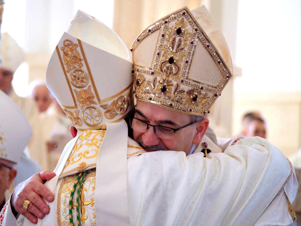 Cardinal Pierbattista Pizzaballa embraces Iyad Twal Cardinal Pierbattista Pizzaballa, facing the camera, embraces Iyad Twal, the newly ordained auxiliary bishop of the Latin Patriarchate of Jerusalem who's facing away from the camera. (Francesca Maria Lorenzini)