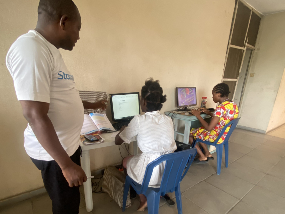 An instructor teaches basic computer knowledge to two of the seven girls at the Ozanam House. Since 1995, the home has housed over 600 girls from the streets of Lagos, Nigeria. (Valentine Benjamin)