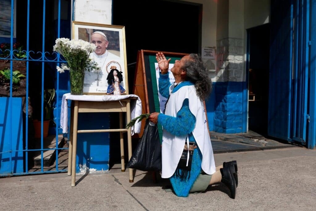 Gregoria Cáceres reza junto a una imagen del papa Francisco colocada afuera de la capilla de la Virgen de Caacupé en Buenos Aires, Argentina, el 21 de abril de 2025, tras el anuncio de la muerte del papa Francisco por parte del Vaticano. (Foto: OSV News/Matias Baglietto, Reuters)