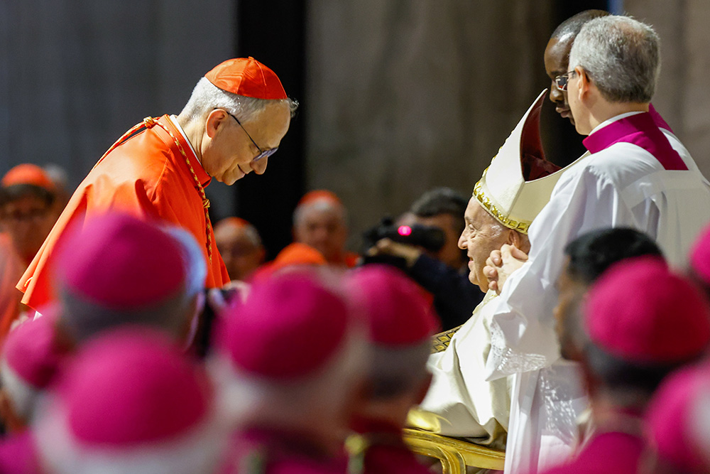 Pope Francis hands Cardinal Robert Prevost, the future Pope Leo XIV, a copy of Spes Non Confundit, ("Hope Does Not Disappoint"), his document proclaiming the Holy Year 2025, during a ceremony in front of the Holy Door of St. Peter's Basilica at the Vatican May 9, 2024. (CNS/Lola Gomez)
