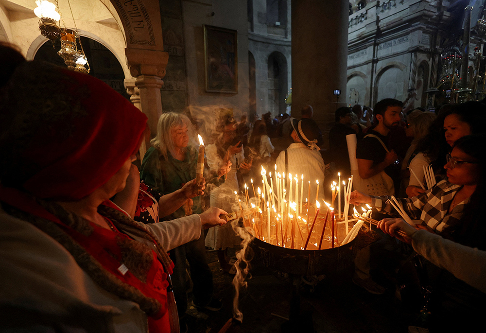 Christian worshippers light candles on the day of Easter Sunday Mass in the Church of the Holy Sepulchre in Jerusalem's Old City, on April 20, 2025. (OSV News/Reuters/Ronen Zvulun)