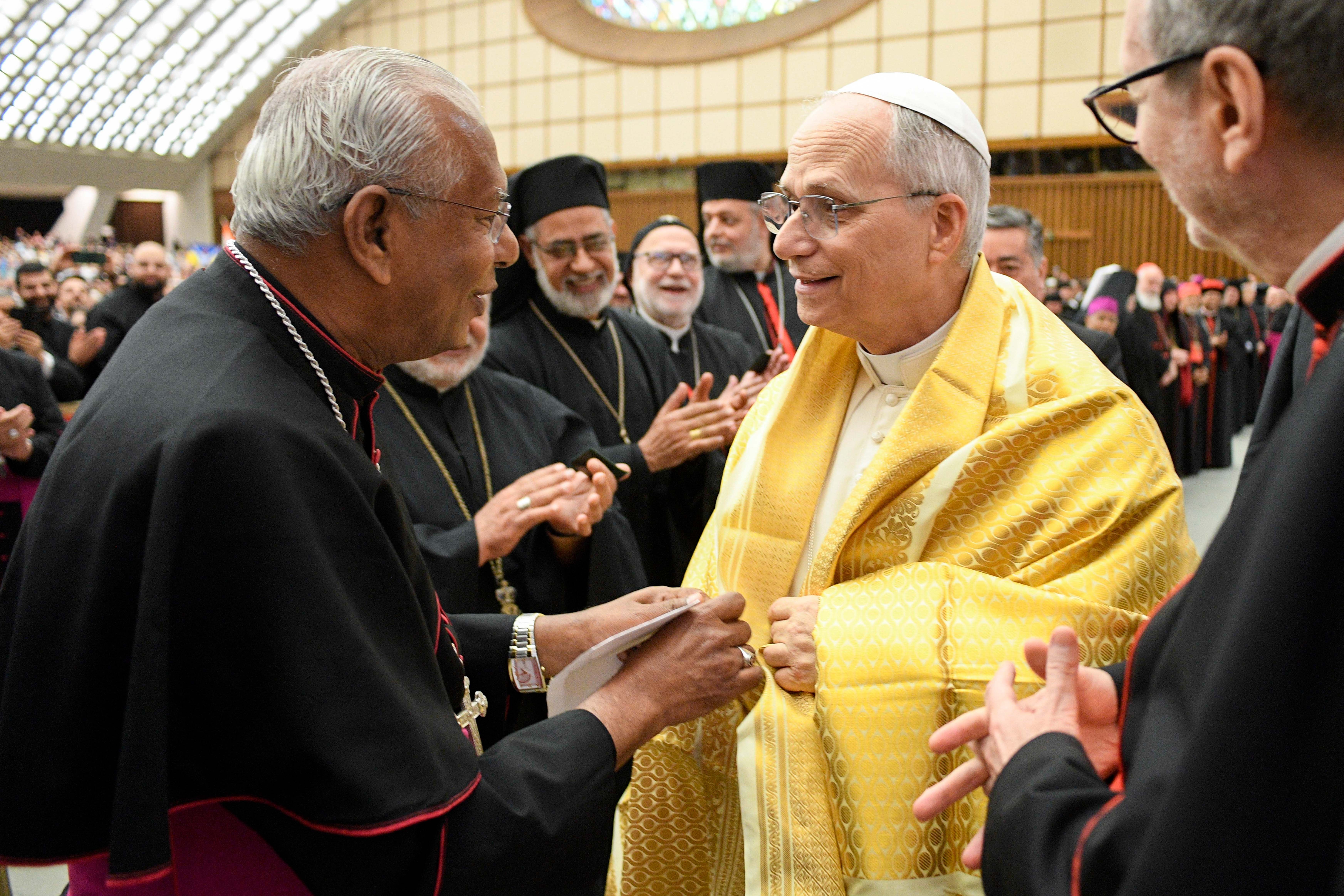  Pope Leo XIV tries on a traditional shawl as he greets participants in the Jubilee of the Eastern Churches in the Paul VI Audience Hall at the Vatican May 14, 2025. 