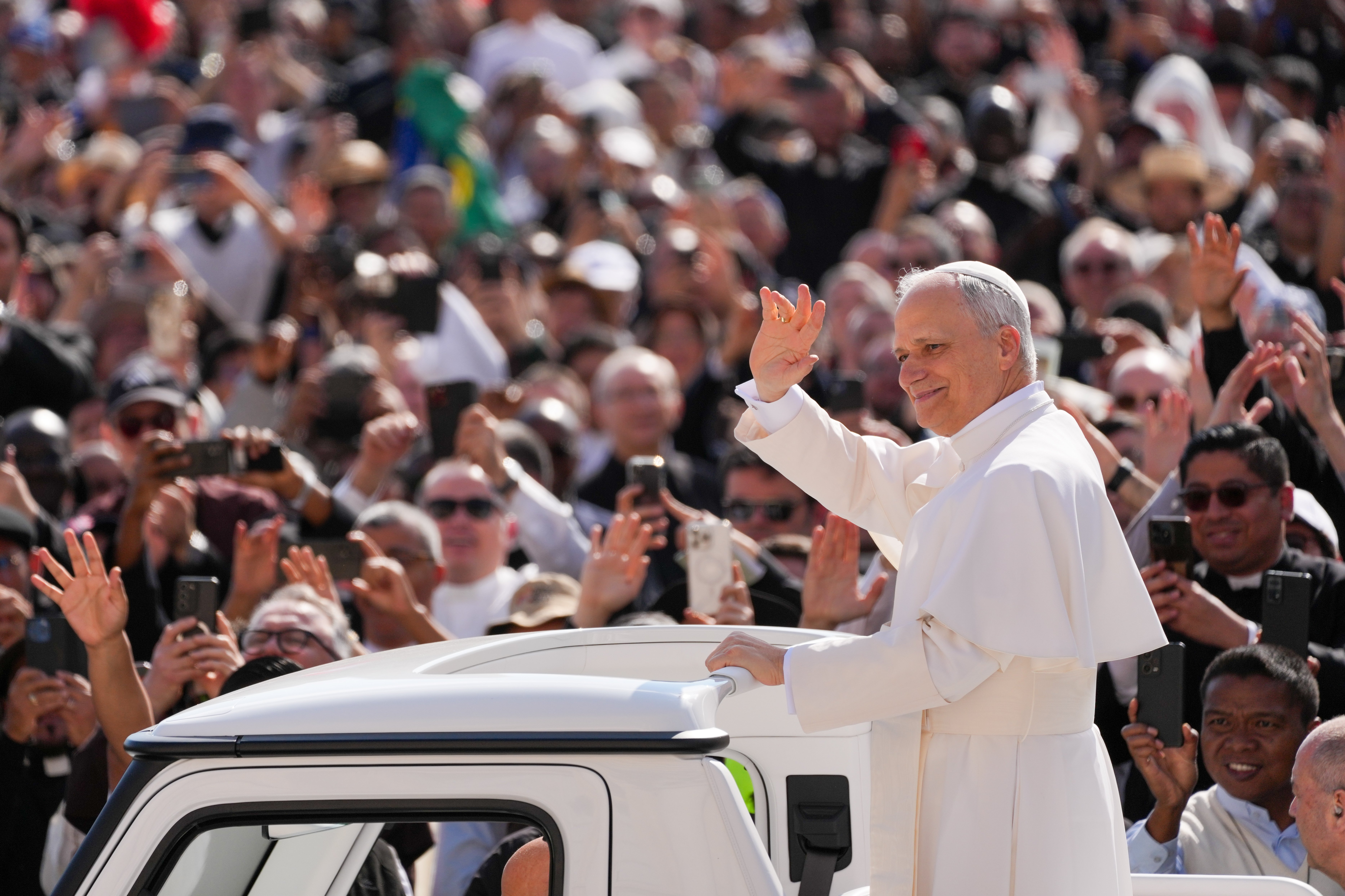 Pope Leo XIV greets the faithful while riding the popemobile through St. Peter's Square before celebrating his installation Mass at the Vatican May 18, 2025. (CNS photo/Lola Gomez)
