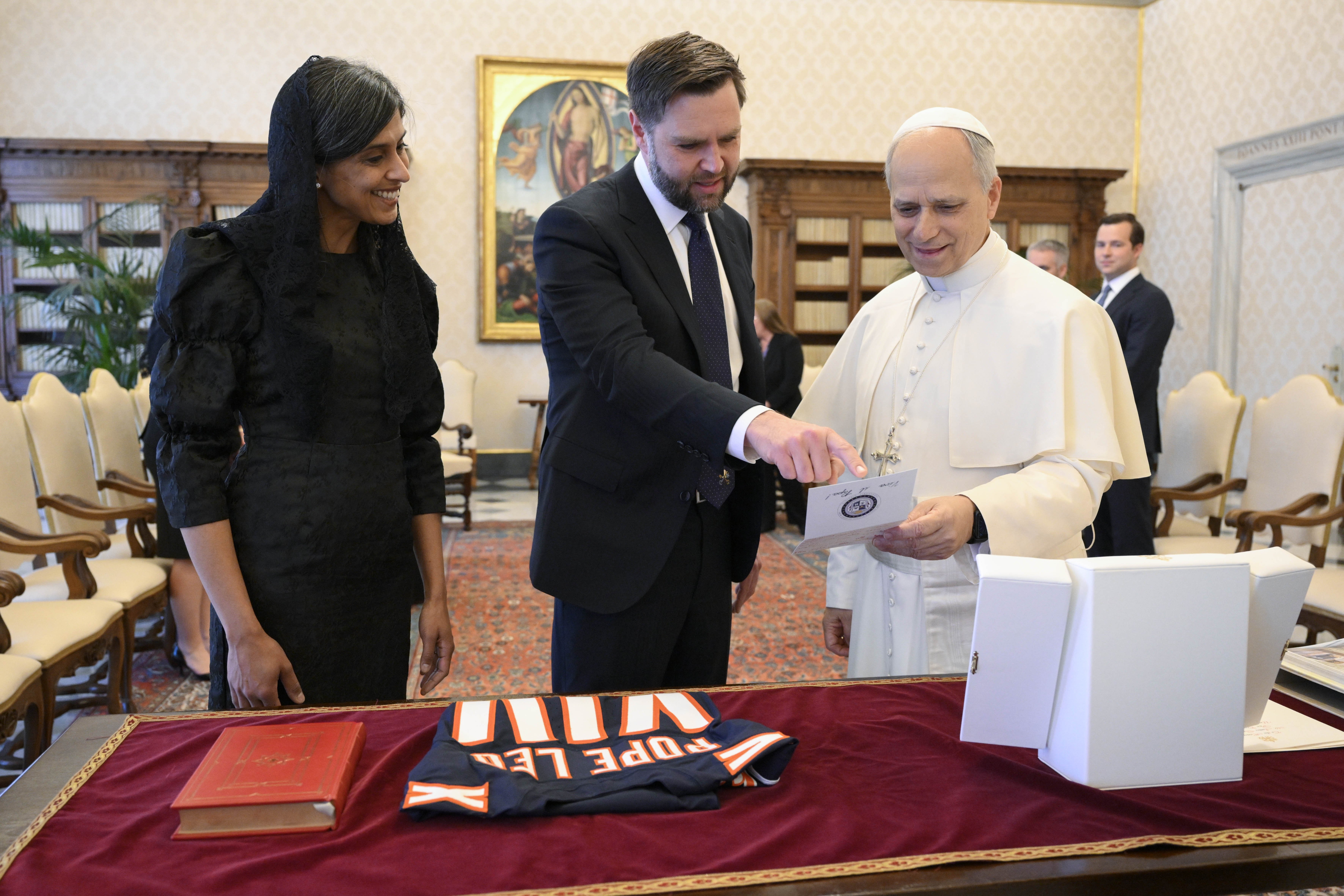 Usha Vance smiles as her husband, U.S. Vice President JD Vance, presents a gift to Pope Leo XIV in the library of the Apostolic Palace at the Vatican May 19, 2025. (CNS photo/Vatican Media)