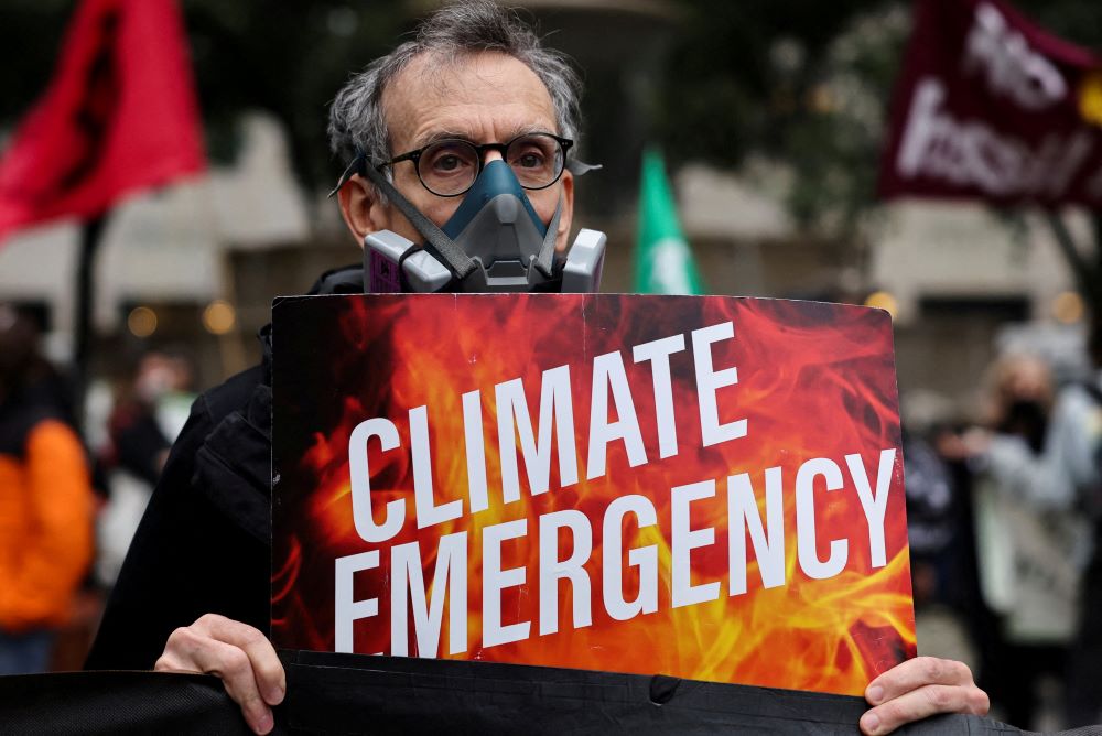 Man holds sign: "Climate Emergency."