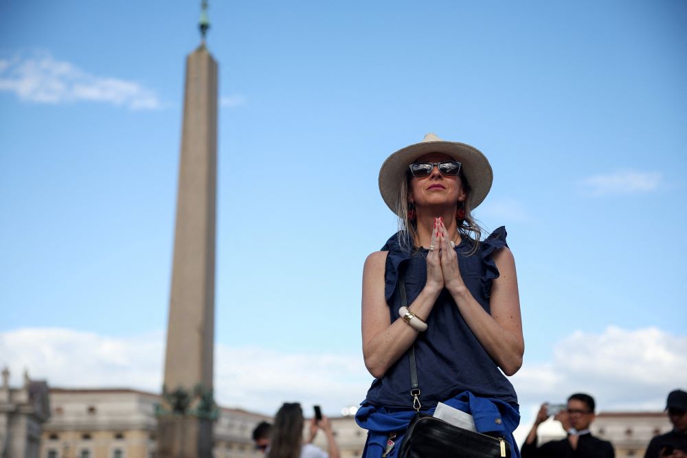 Woman prays in St. Peter's Square.
