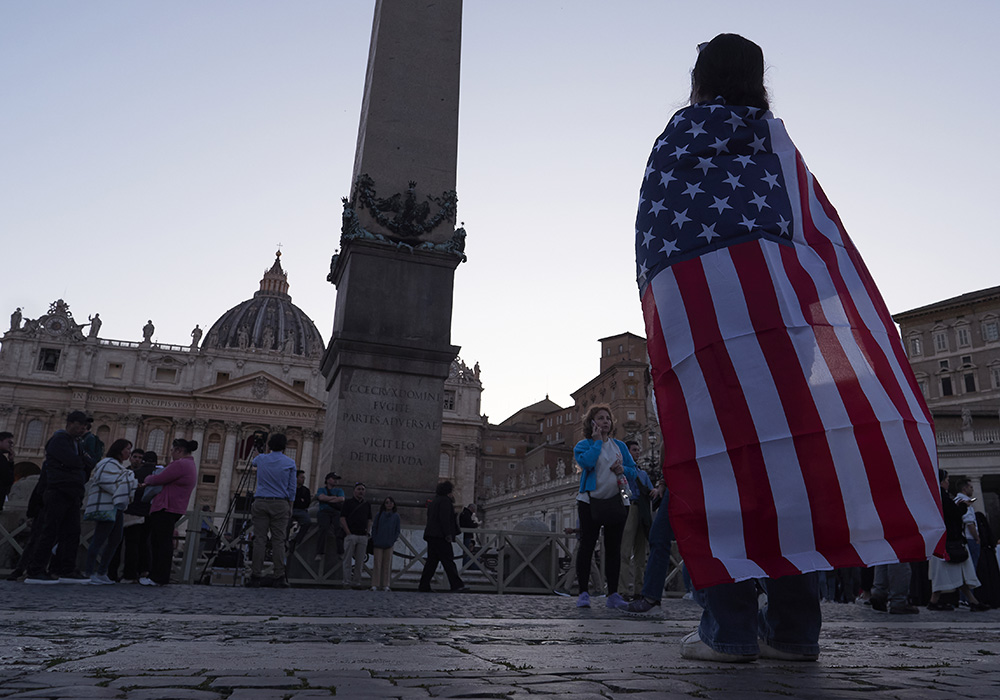Andrea Gallardo, 20, from Texas, wears a flag of the United States after Pope Leo XIV appeared on the balcony of St Peter's Basilica following his election, at the Vatican, on May 8, 2025. (AP photo/Paolo Santalucia)