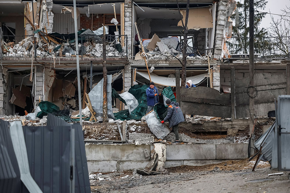 Men clear rubble near destroyed homes in the town of Hostomel in Ukraine's Kyiv region March 19, 2025, at the site of a Russian drone strike. (OSV News/Reuters/Alina Smutko)