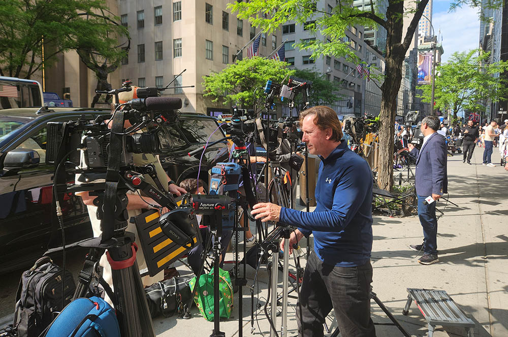 Television broadcast personnel line Fifth Avenue in Manhattan outside of St. Patrick's Cathedral on May 8 after news of the selection of Pope Leo XIV. (NCR photo/Chris Herlinger)