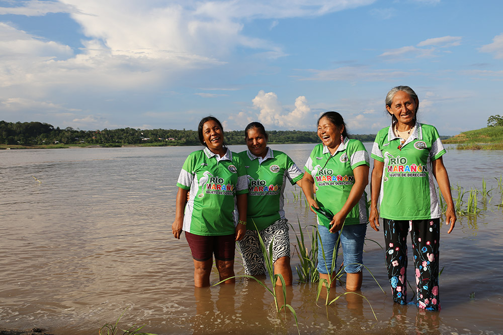 Leaders of Huaynakana Kamatahuara Kana stand in the Marañón River in Peru. Mari Luz Canaquiri is second from right. (Quisca Productions/Miguel Araoz)