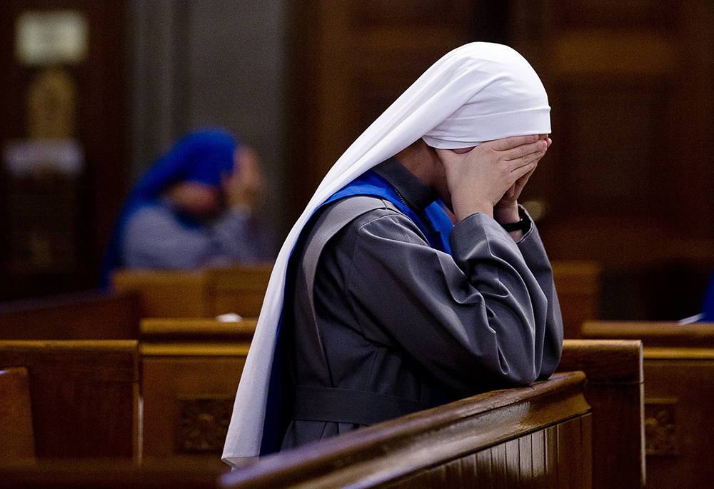 A novice prays prior to the start of her profession of vows in this 2017 file photo. (CNS/Tyler Orsburn)