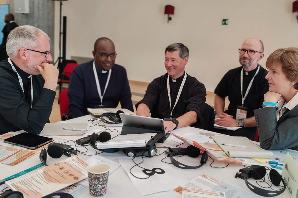 Sacerdotes trabajan en un pequeño grupo de habla inglesa, el 30 de abril de 2024, con la facilitadora María Cimperman,  religiosa del Sagrado Corazón de Jesús [a la derecha], como parte de una reunión de párrocos de todo el mundo reunidos en Sacrofano, en las afueras de Roma, para compartir sus experiencias y contribuir al Sínodo sobre la Sinodalidad en curso. (Foto: CNS/cortesía del Sínodo de los Obispos)