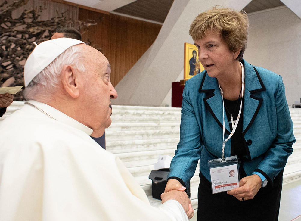 El papa Francisco saluda a la delegada sinodal María Cimperman, religiosa del Sagrado Corazón de Jesús, antes de una sesión de trabajo del Sínodo de los Obispos sobre la Sinodalidad en el Vaticano, el 4 de octubre de 2024. (Foto: CNS/Vatican Media)
