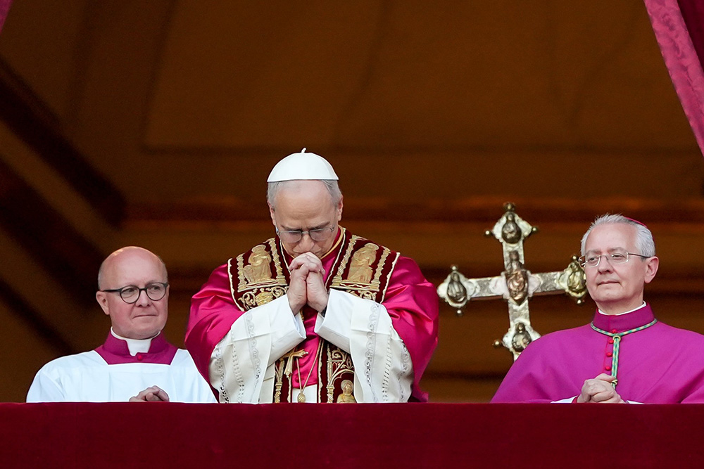 Pope Leo XIV, the former Cardinal Robert Prevost, prays as he stands on the central balcony of St. Peter’s Basilica at the Vatican after his election as pope May 8, 2025. (CNS/Lola Gomez)