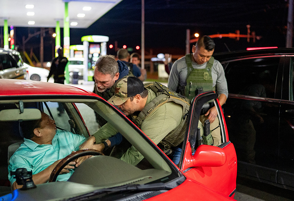 U.S. Immigration and Customs Enforcement officers detain a man from a car stopped by Tennessee Highway Patrol at a gas station in South Nashville, as he could not produce any alternative identification proof other than his expired driving license, during an operation conducted by ICE along with THP to detain noncitizens across the city of Nashville, Tennessee, on May 10, 2025. (OSV News/Reuters/Seth Herald)