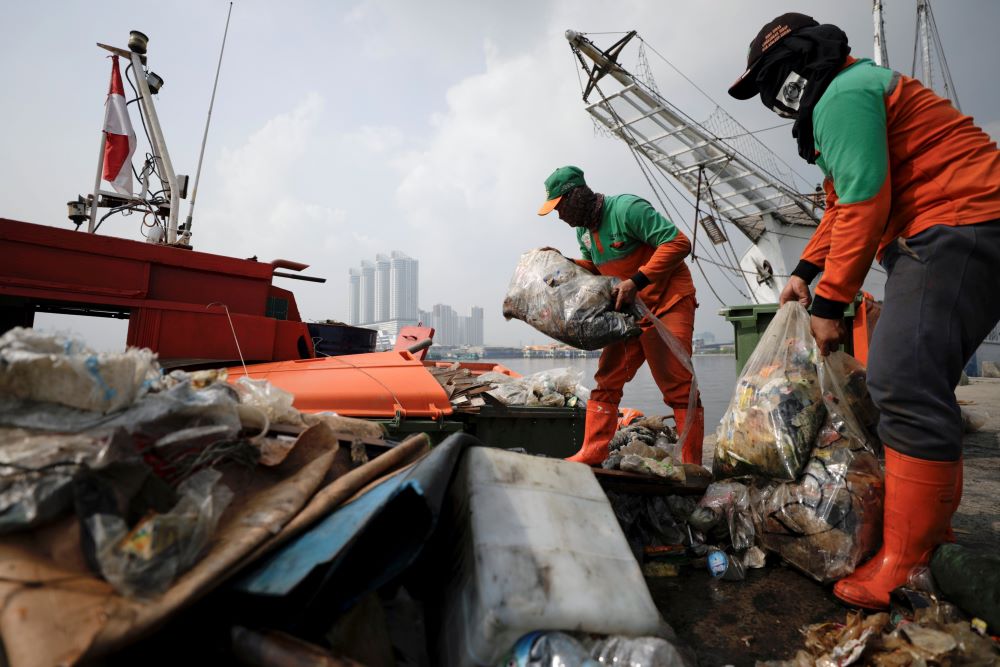 Municipal workers unload bags of garbage collected from the shore in Jakarta, Indonesia. 
