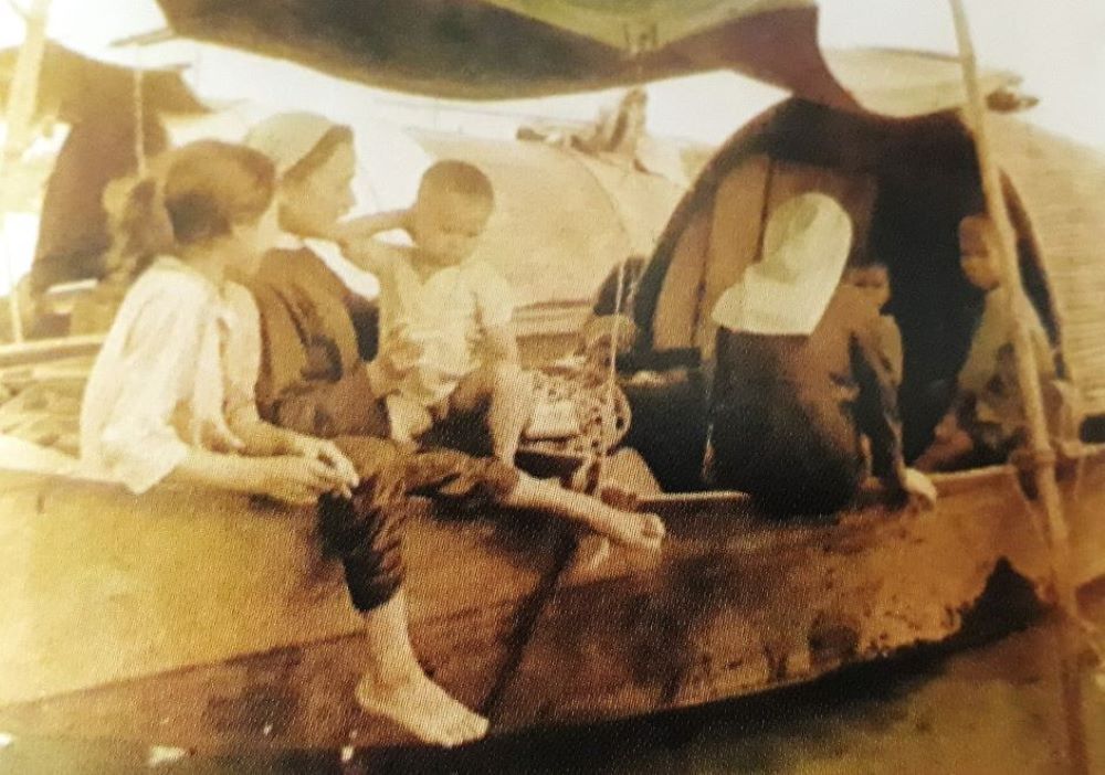 Two Daughters of Our Lady of the Visitation visit people living on a boat in a river in Hue in 1970. (Courtesy photo)