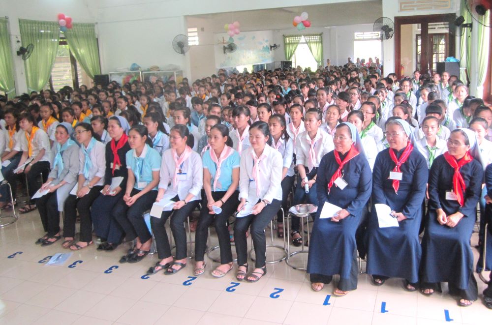 Young women sit in audience for event.