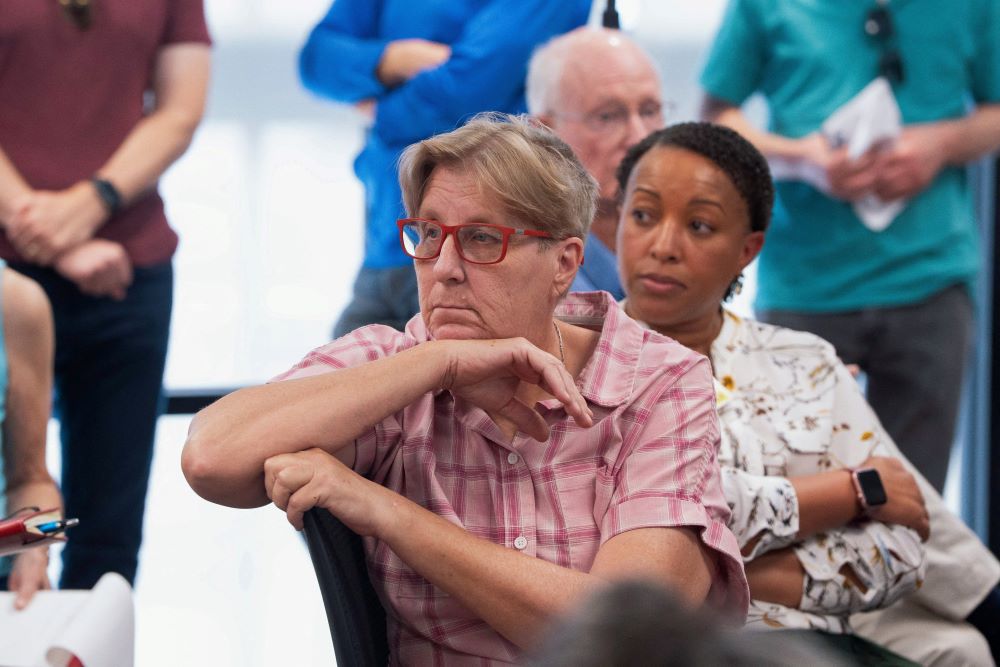 Women listen during town hall meeting.