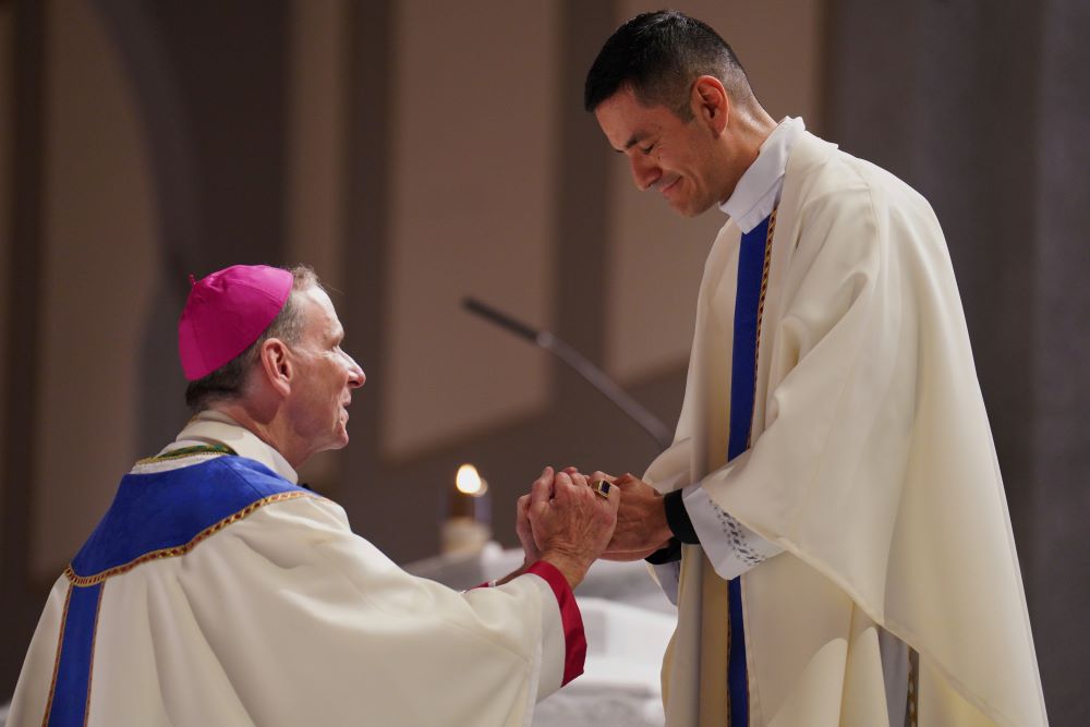 New priest blesses bishop.