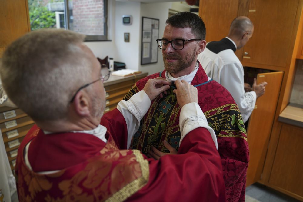 Fr. Donald Planty, left, assists Fr. Tim Banach with a microphone before Banach's first Mass at St. Charles Borromeo Catholic Church in Arlington, Va., on June 8. (AP/Jessie Wardarski) Fr. Donald Planty, left, assists Fr. Tim Banach with a microphone before Banach's first Mass at St. Charles Borromeo Catholic Church in Arlington, Va., on June 8. (AP/Jessie Wardarski)