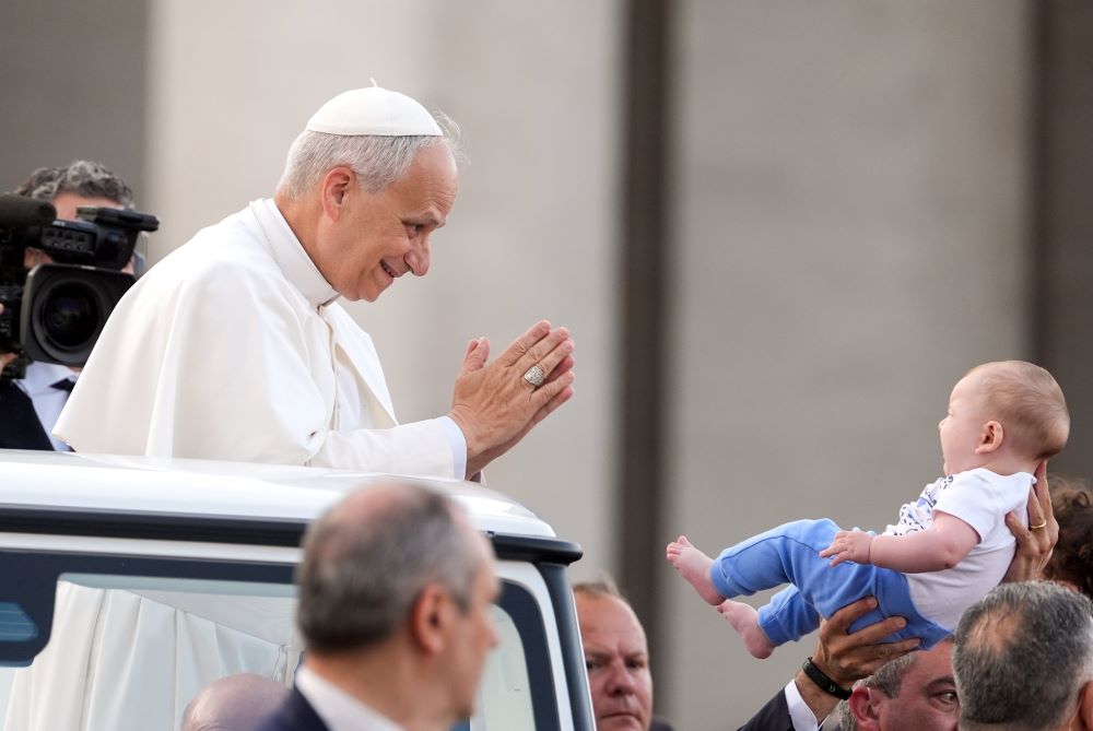 Pope Leo greets a child.