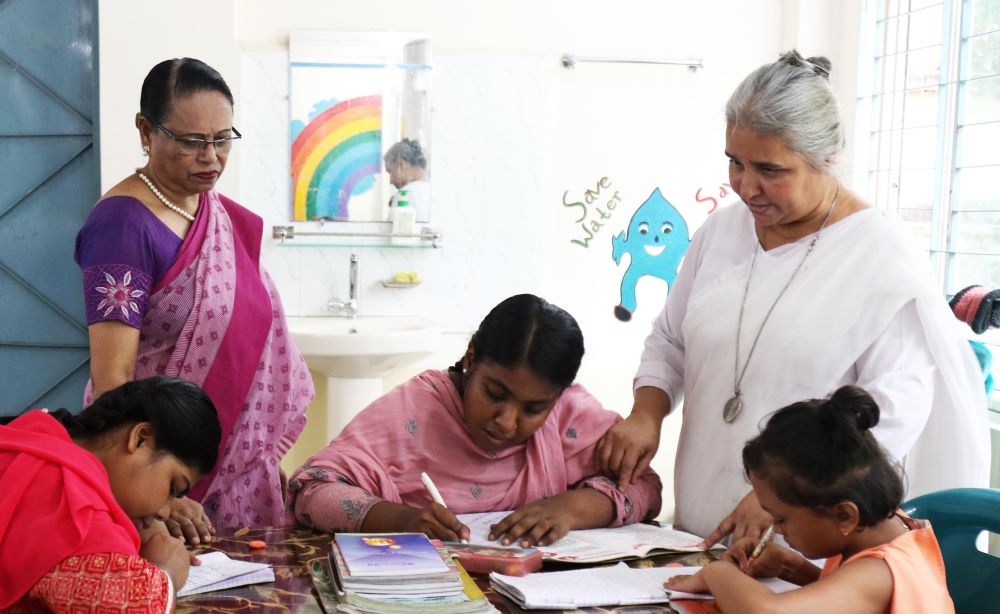 Sr. Nita Rozario with children at table 