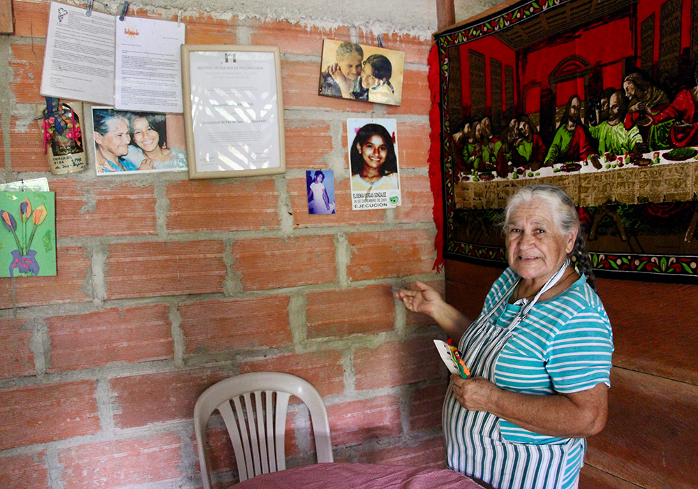 Brígida González, de la Comunidad de Paz de San José de Apartadó (Colombia), ante el Muro de la Memoria dispuesto en su casa. (Foto: Tracy L. Barnett)